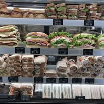 Deli case filled with freshly made sandwiches, rolls and wraps